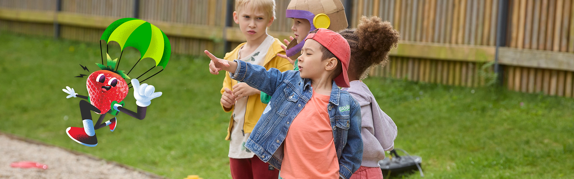 Kid with his friends pointing at a strawberry with parachute